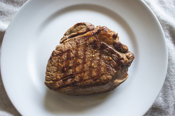 Grilled steak on white plate