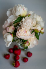 peonies in a vase with strawberries
