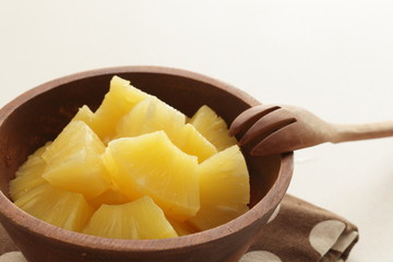 Canned food, pineapple in wooden bowl with copy space