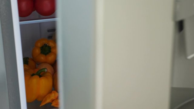 Opened fridge full of fresh colorful orange fruits and vegetables, healthy nutrition concept, nobody