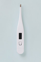 White digital thermometer on a gray background