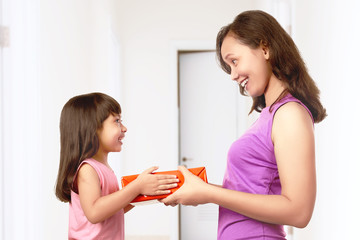 Asian little girl giving her mother a gift box