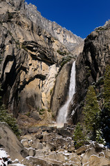 Fototapeta na wymiar Rock fractures at Lower Yosemite Falls in winter after a snowfall with blue sky