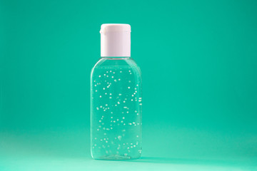 A bottle of hand sanitizer gel. Hand hygiene as coronavirus protection. Antivirus and antibacterial product. Green liquid with white round granules. Copy space for text