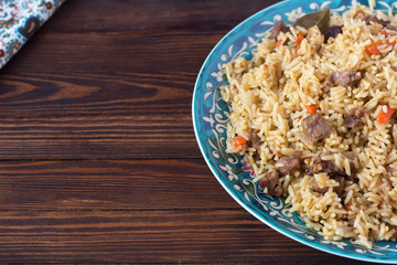 pilaf in a plate with a national pattern, Uzbek dishes, oriental cuisine, close-up