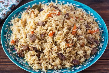pilaf in a plate with a national pattern, Uzbek dishes, oriental cuisine, close-up