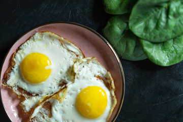Healthy homemade scrambled eggs with spinach on a dark background.