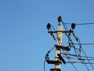 Utility pole for electrical wires against a cloudless sky