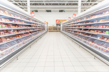 Shelves with chilled food in a supermarket. Space for text. Blurred.