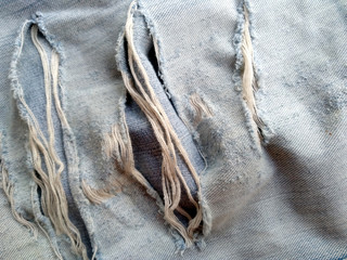 Jeans torn denim texture. Blue jeans background. Ripped destroyed jeans background.