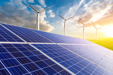 Solar panels with wind turbines in the setting sun,green energy.