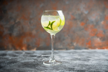 Rum based cocktail with lime in wine glass (variation of cuba libre) on the rustic background. Selective focus. Shallow depth of field.