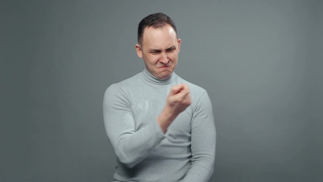 Video of young man in turtleneck picking his nose