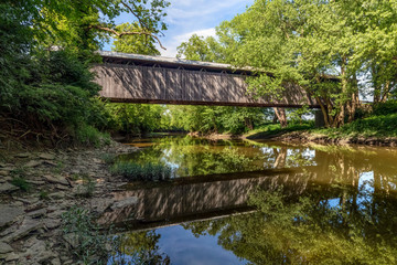 Displaying a beautiful reflection in the East Fork of the Little Miami River, historic McCafferty Road Covered Bridge was built in 1877 in rural Brown County, Ohio. - 336586038