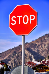 Stop Sign on the background of blue sky in the mountains
