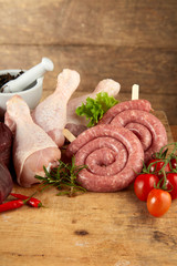 Uncooked sausage coils and chicken legs