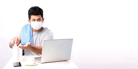 Business Asian man working from home wearing protective mask.in quarantine for coronavirus wearing protective mask. Working from home. Cleaning his hands with Alcohol gel. in studio With copy space.