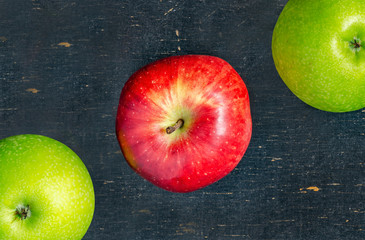 Red and green fresh apples on a black background. Top view