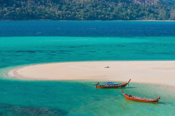A girl was sunbathing on the crystal clear beach with the white sand dune in Koh Lipe island, Thailand, Andaman sea.