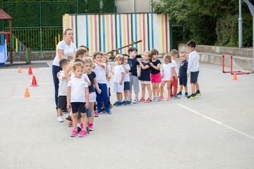 Group of children standing in column and waiting for lesson start.  Sport school