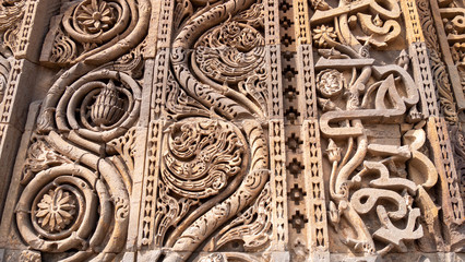 close up of carved inscription in arabic set in a sandstone wall at qutub minar complex in new delhi