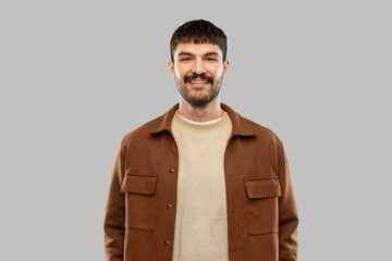people concept - portrait of happy smiling young man with mustaches over grey background