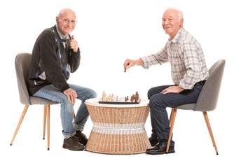 Portrait of elderly men playing chess on white background