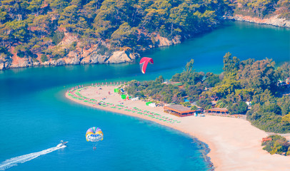 Happy people parasailing on Oludeniz Beach in summer - Fethiye, Turkey