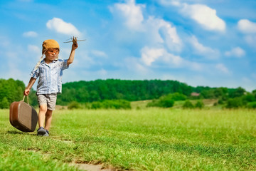 A Baby boy by the plane plays on nature in the park. Boy on vacation pilot.