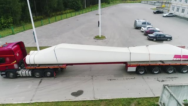 Impressive view from an unmanned quadrocopter, truck movement, tractor, shipping, wind generator, highway, road, top view, no camera movement, transport and infrastructure development.