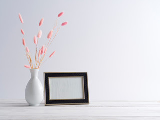Black frame mockup with grass flowers.