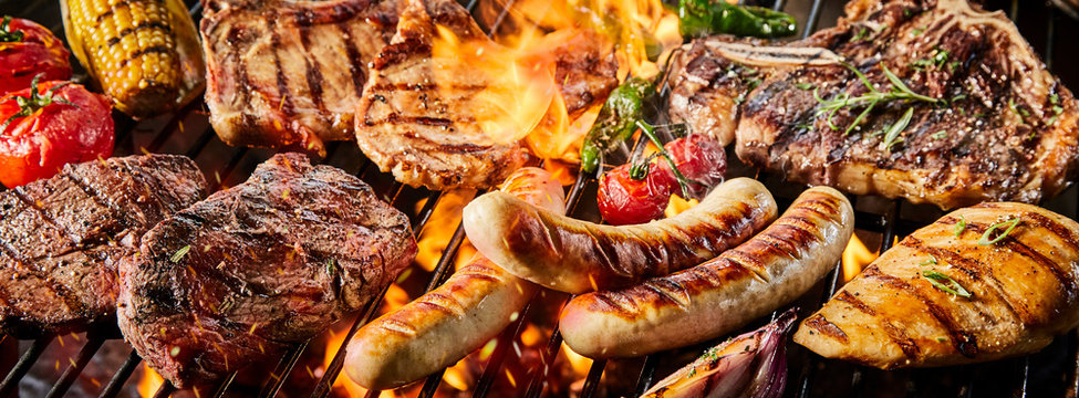 Various kinds of pork meat and sausages on grill