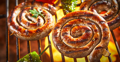 Coils of barbecued sausage on a hot fire