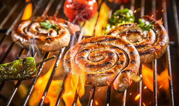 Spirals of spicy sausage grilling on a BBQ