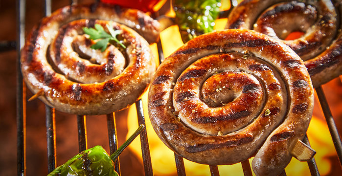 Coils of barbecued sausage on a hot fire