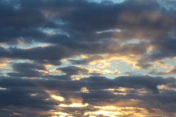 The suns rays pass through the dark clouds. Beautiful dramatic sky at sunset or sunrise.