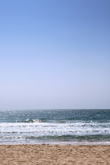 Fototapeta na wymiar Waves Breaking Over an Empty Beach