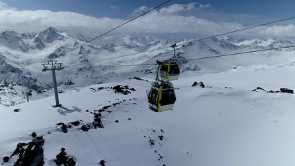 Flight with cable car cabin lift alpine funicular modern cableway elevator carriages ride. Epic winter mountain landscape Caucasus Switzerland Alps ski. Snowy rocky slopes peaks. Sport travel tourism