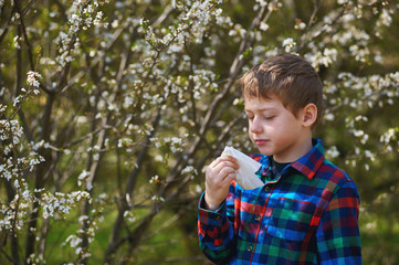 allergies from flowering trees . A boy with a handkerchief escapes from a spring Allergy .