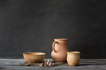 Set of ceramic dishes on a wooden table. Still life in a rustic style. Natural light from a window.