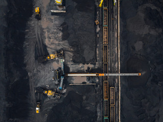 Loading coal anthracite mining in port on cargo tanker ship with crane bucket of train. Aerial top...