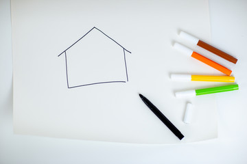 Drawing on paper roll on white table. A house drawing with colorful markers, stay home stay safe while quarantine.