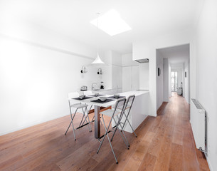 New stylish bright kitchen with white cabinets. Spacious modern interior with wooden floor, white table, industrial chairs and big ceiling window.
