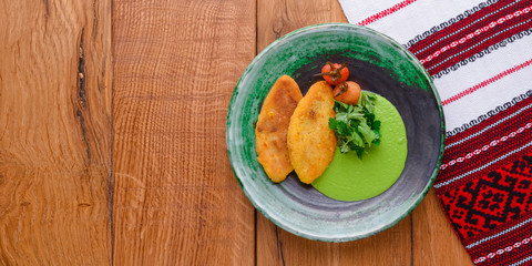 Minced meat cutlets with vegetable puree served on blue plate over brown wooden background