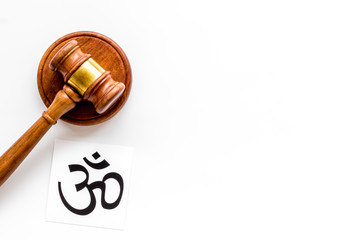 Om - Buddhist inner peace symbol - on white desk top view. Religious conflict concept. Copy space