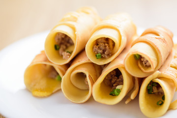 Thai dessert (Khanom Tokyo), pancake roll stuff with minced pork on white plate