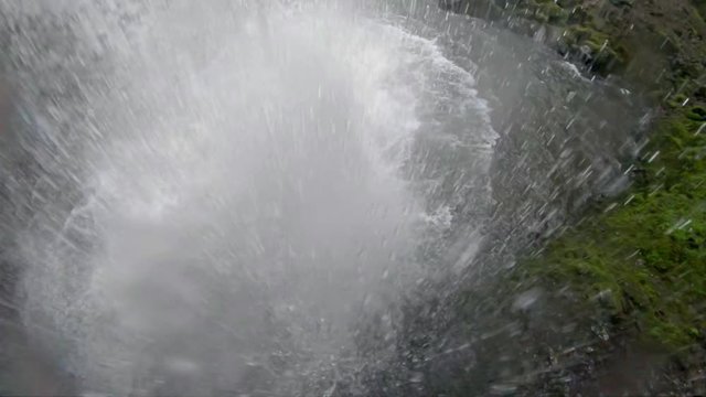 POV of jumping through a water fall into a plunge pool