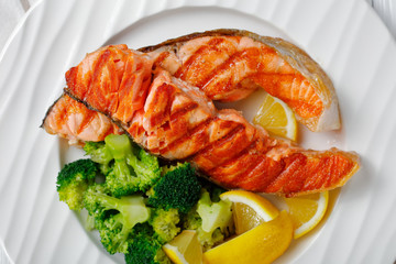 Grilled salmon with broccoli and lemon, close-up