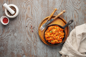 Stewed cabbage in skillet on wooden background in rustic style. Top view