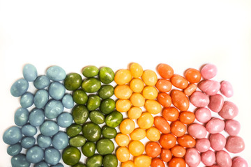 assorted bean candies making a rainbow on a white background